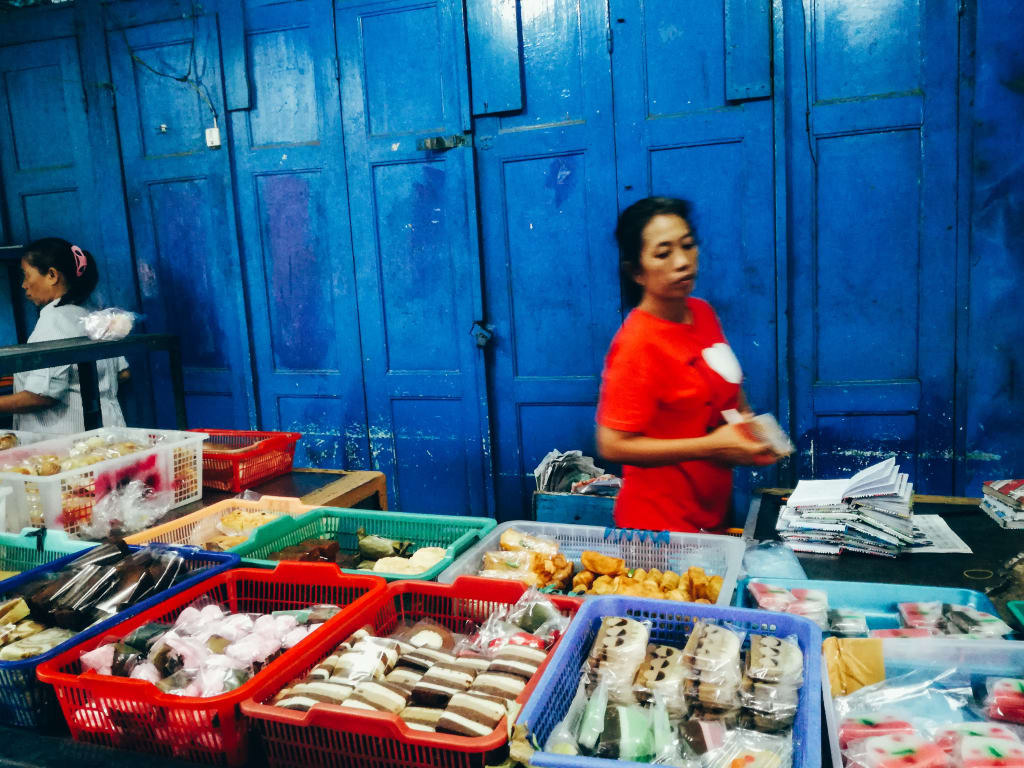 Mercato locale con venditrice in abiti tradizionali a Bali, Indonesia.
